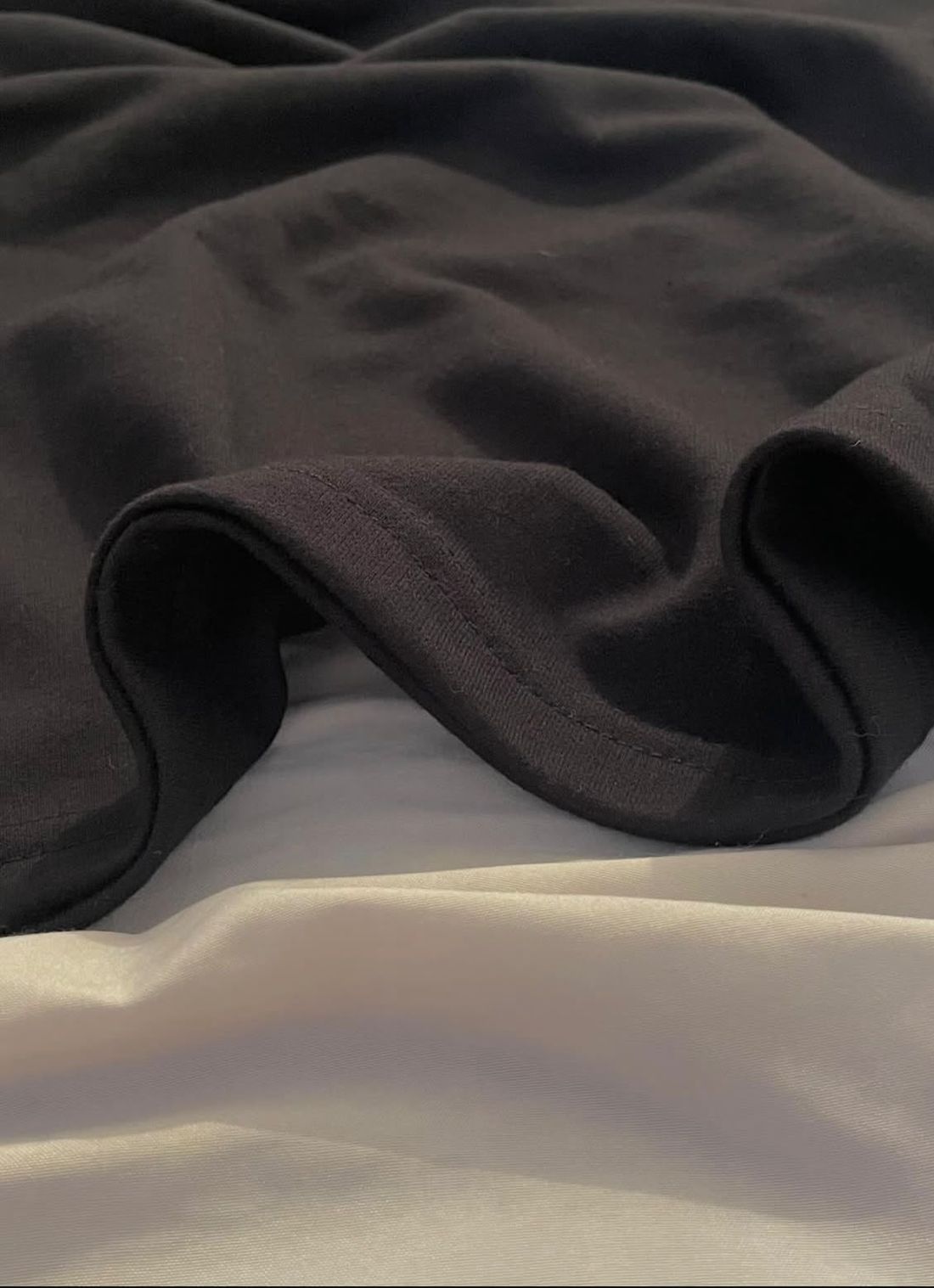 Close-up of the black cotton jersey folding over itself