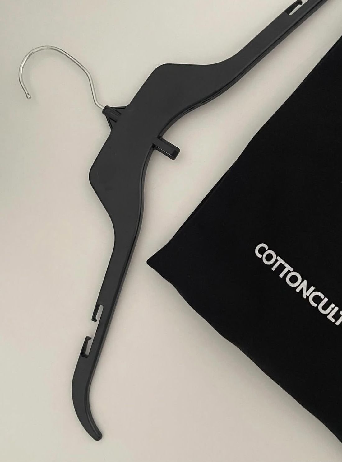 Black hanger beside the printed dust bag